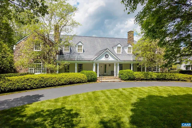 a front view of a house with a yard and potted plants