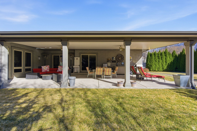 145 Carnesecca Court Mapleton, UT 84664 - Photo 89 of 109 Back of property featuring a yard, a patio area, an outdoor living space, stucco siding, and a ceiling fan