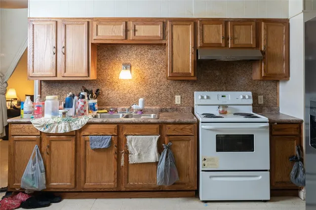 a kitchen with stainless steel appliances granite countertop a stove and a white cabinets