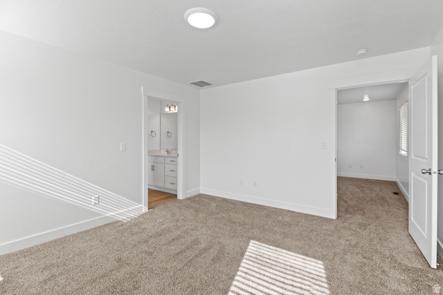 1271 West 500 South Logan, UT 84321 - Photo 13 of 26 Spacious room featuring neutral carpeting, a modern recessed ceiling light, and white baseboards
