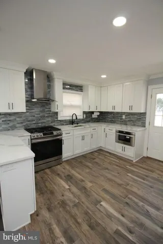 a kitchen with a sink appliances cabinets and a counter top space