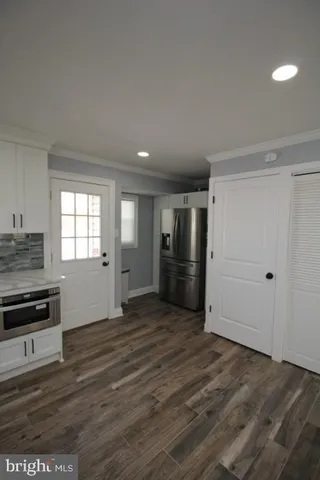 a bedroom with a bed two windows and a window