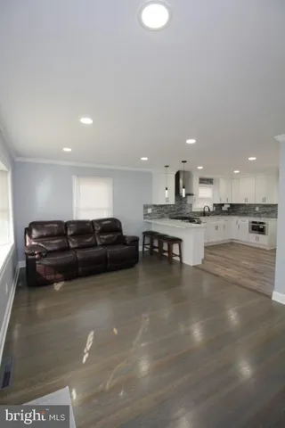 a large kitchen with stainless steel appliances granite countertop a stove a sink a refrigerator and a granite counter tops with wooden floors