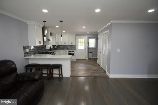 a kitchen with a sink and a stove top oven with wooden floor