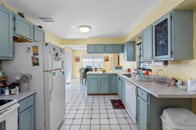 a kitchen with a sink a refrigerator and cabinets
