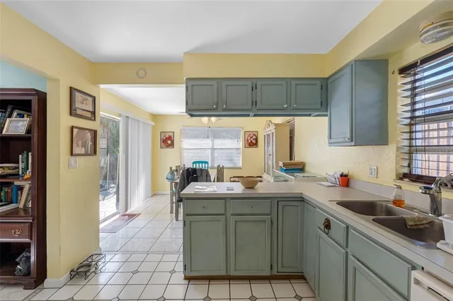 a kitchen with a sink window and cabinets