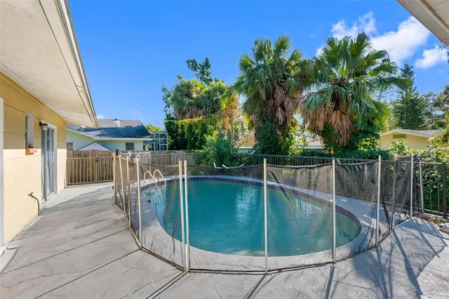 a view of a swimming pool with a deck and a yard