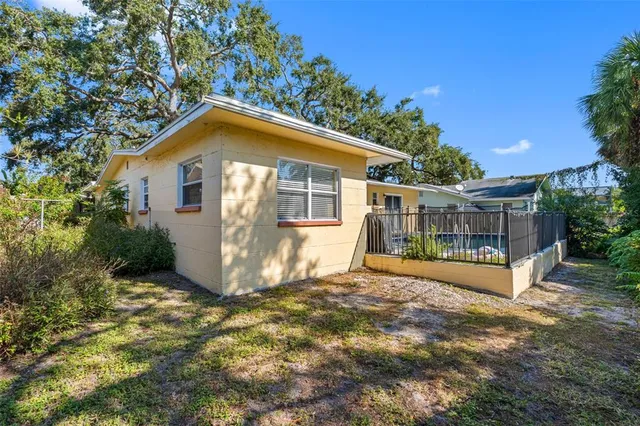 a view of a house with wooden fence next to a yard
