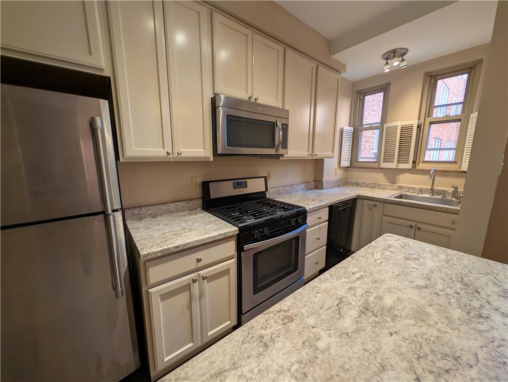 144 North Dithridge Street, Unit 403 Pittsburgh, PA 15213 - Photo 5 of 31 a kitchen with a sink stove and refrigerator