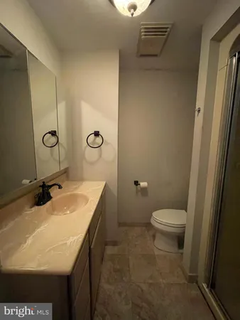 a bathroom with a granite countertop sink toilet and mirror