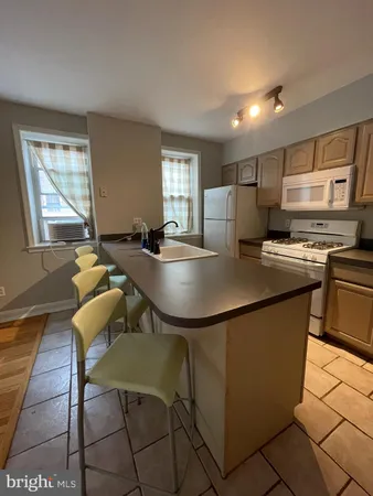 a kitchen with kitchen island a stove a table and chairs