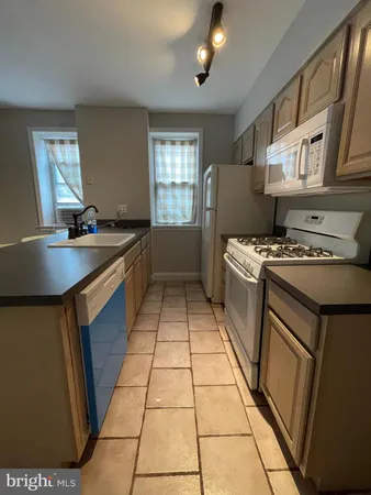 a kitchen with a sink a stove cabinets and a counter top space