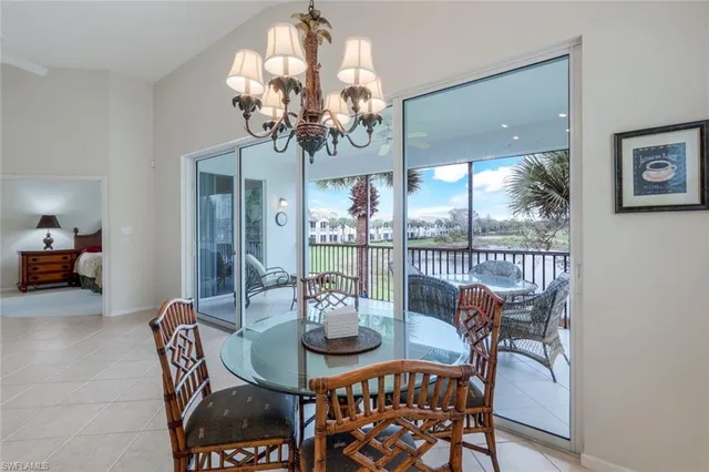 a view of a dining room with furniture a chandelier and large window