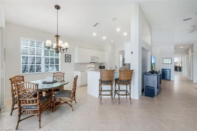 a view of a dining room and livingroom with furniture wooden floor a chandelier
