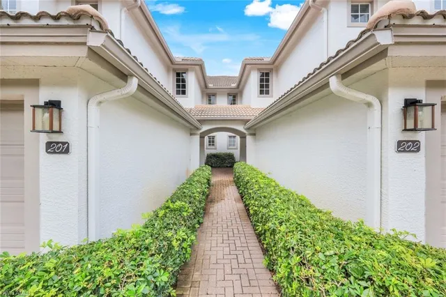 a view of a pathway of a house with a lot of flower plants