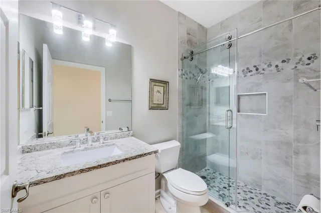a bathroom with a granite countertop sink toilet and shower