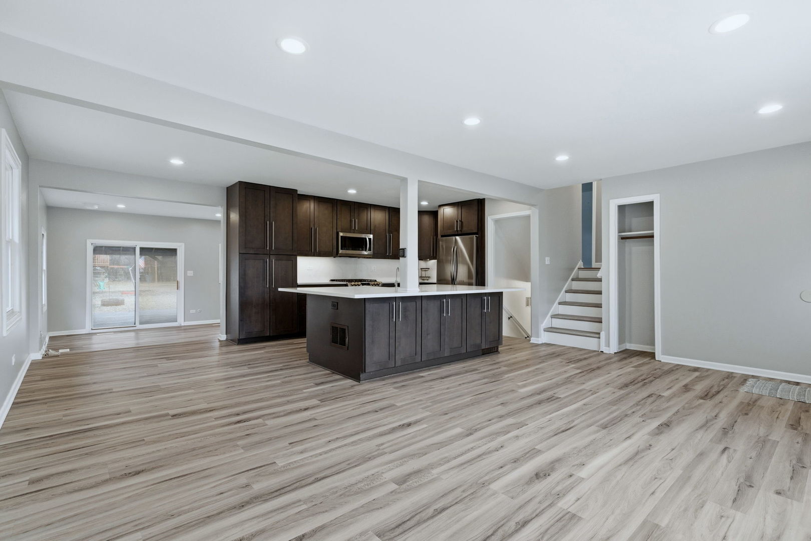 28-w032 Roosevelt Road Winfield, IL 60190 - Photo 4 of 35 a view of kitchen with microwave oven a refrigerator and white cabinets with wooden floor