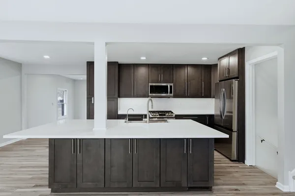 a kitchen with a refrigerator a sink and wooden cabinets