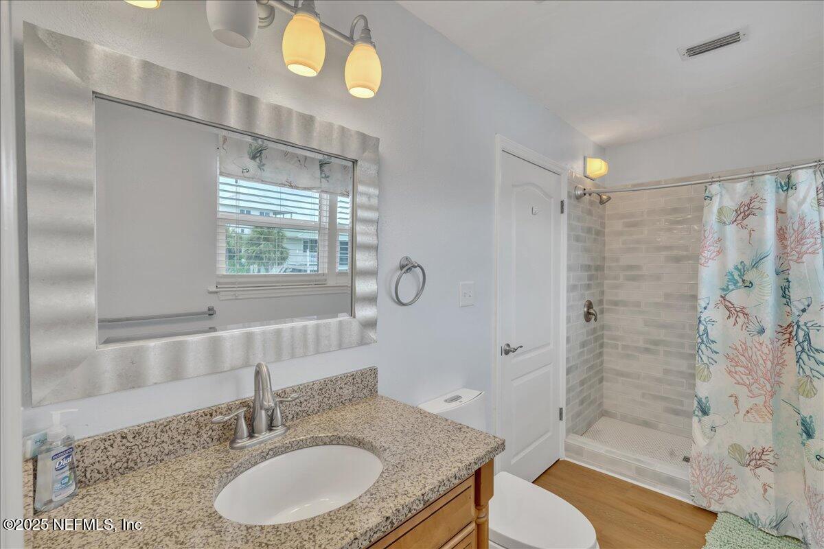 4491 Surfside Lane Port St. Joe, FL 32456 - Photo 24 of 84 a bathroom with a granite countertop sink toilet mirror and shower