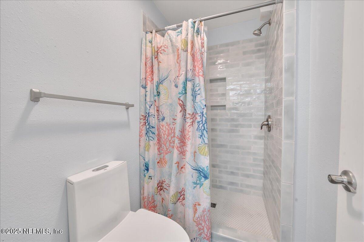 4491 Surfside Lane Port St. Joe, FL 32456 - Photo 35 of 84 a bathroom with a shower curtain and a toilet