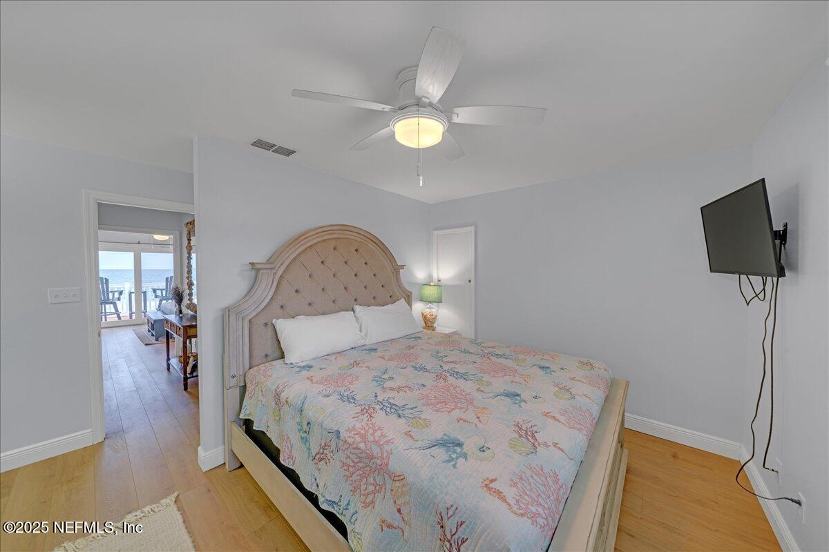 4491 Surfside Lane Port St. Joe, FL 32456 - Photo 37 of 84 a bedroom with a bed and a lamp with the wooden floor