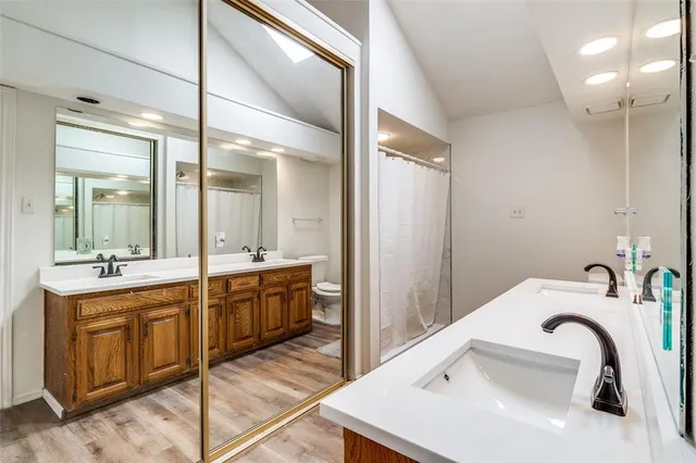 a bathroom with a sink and mirror with bathtub