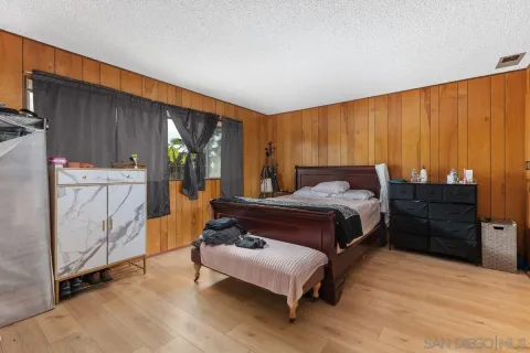 a bedroom with a bed window and a dresser