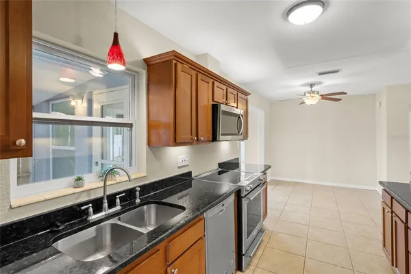 a view of a livingroom with a chandelier fan and windows