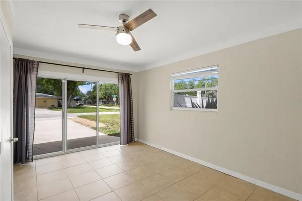 an empty room with a ceiling fan and a window