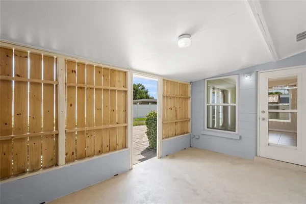 a view of a backyard with plants and palm trees