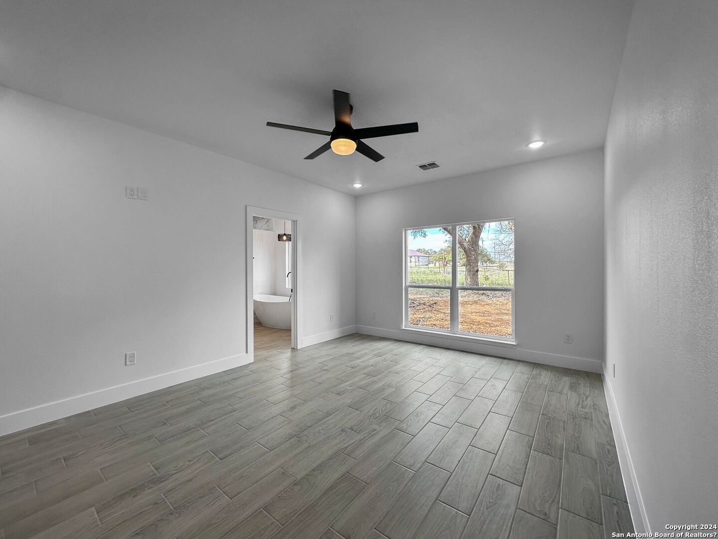 142 North Lon Price Blanco, TX 78606 - Photo 5 of 14 an empty room with wooden floor and windows
