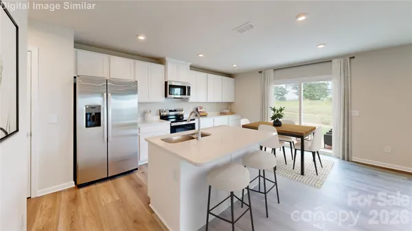 a kitchen with a table chairs refrigerator and microwave