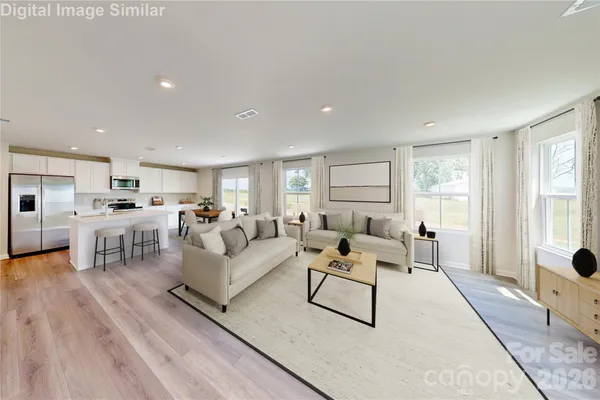 a living room with furniture white walls and wooden floor