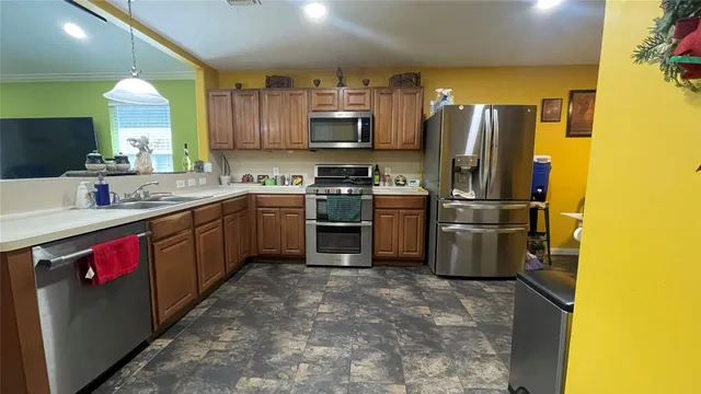 a kitchen with refrigerator a sink a stove and cabinets