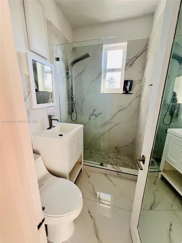 a white toilet sitting next to a bathroom sink