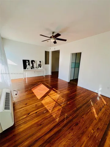 a view of a room with wooden floor and ceiling fan