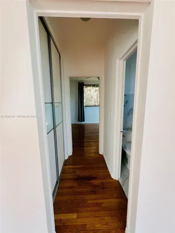 a view of a hallway with wooden floor and staircase