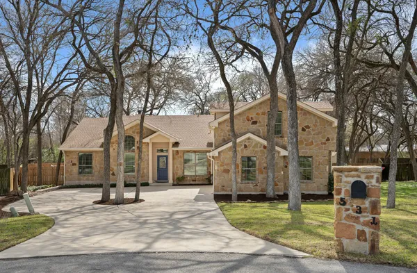 a view of a white house with a large tree and a yard