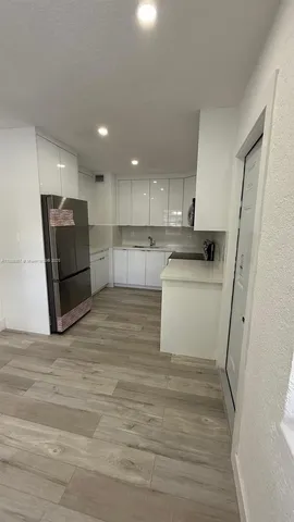 a view of a hallway with wooden floor and closet
