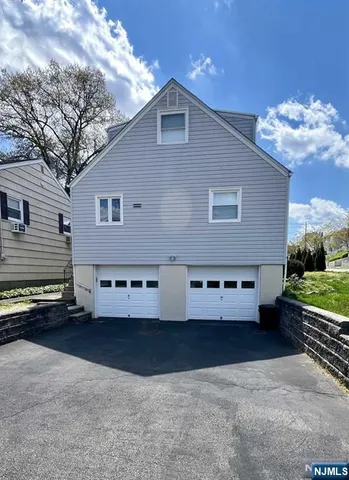 a front view of a house with a yard and potted plants