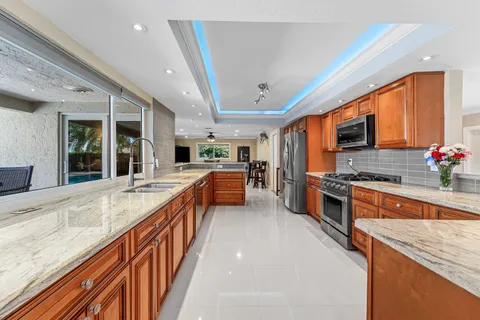 a large kitchen with stainless steel appliances granite countertop sink stove and cabinets