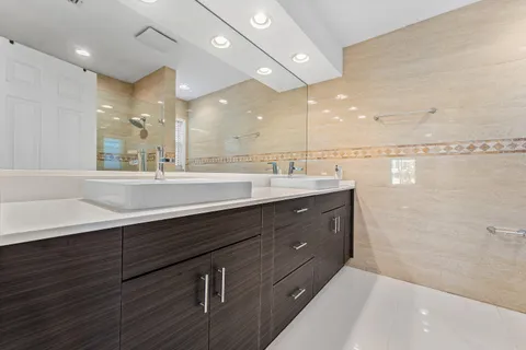 a bathroom with a sink mirror and a shower