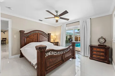 a bedroom with a bed a chandelier and dresser