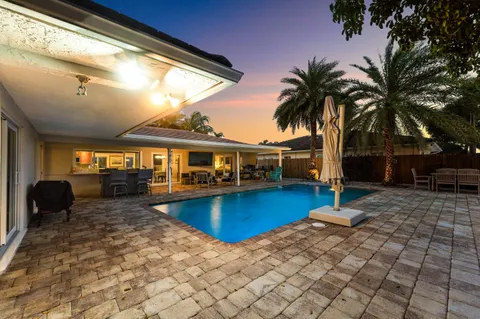a front view of a house with swimming pool and furniture