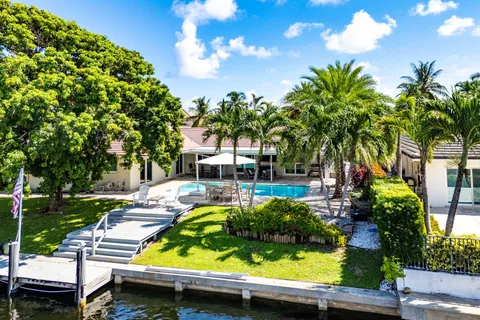 a view of a swimming pool with a patio and plants