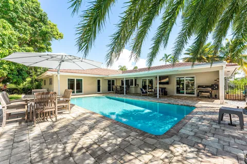 a view of a house with a yard patio and swimming pool