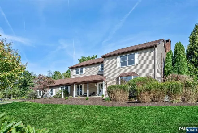 a front view of a house with a yard and potted plants