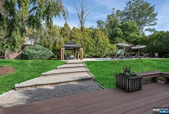 a view of a swimming pool with lawn chairs under an umbrella