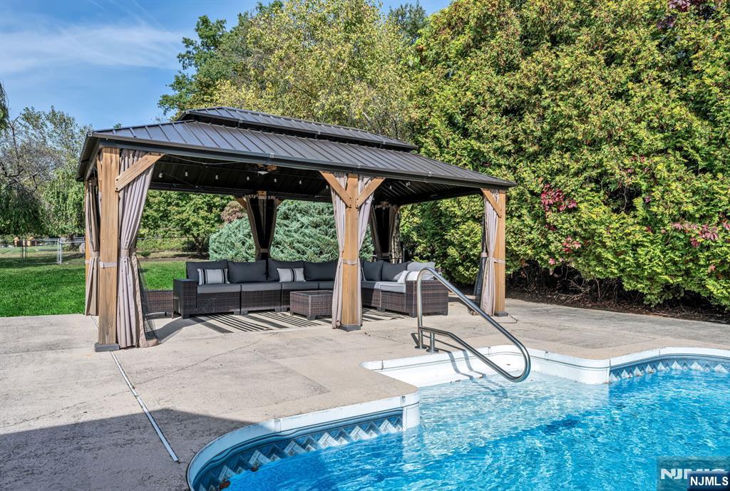 15 Cobbler Lane Mahwah, NJ 07430 - Photo 45 of 50 a backyard of a house with table and chairs under an umbrella