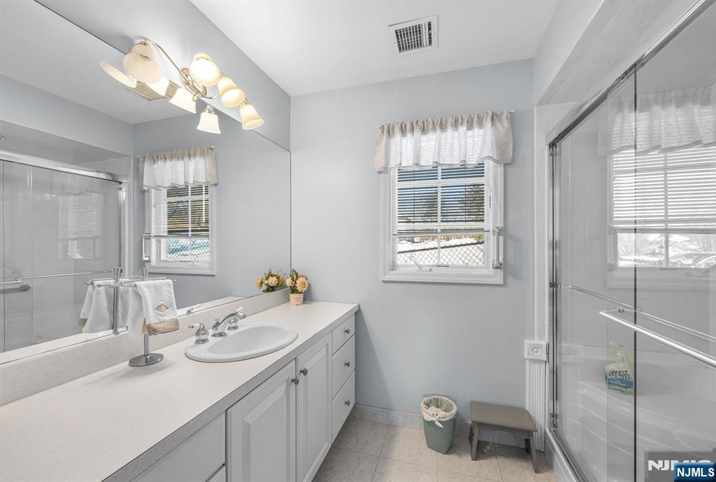 15 Cobbler Lane Mahwah, NJ 07430 - Photo 49 of 50 a bathroom with a sink a large mirror and a window